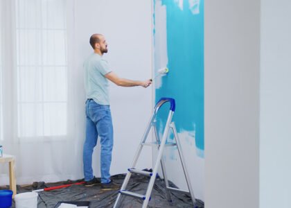 painting-apartment-wall-with-white-paint-using-roller-brush-handyman-renovating-apartment-redecoration-home-construction-while-renovating-improving-repair-decorating